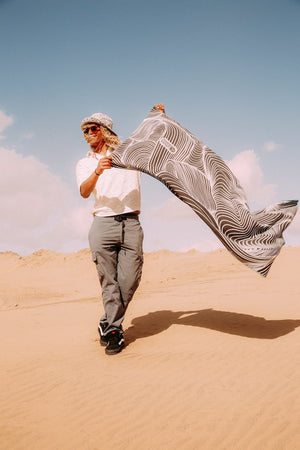 A man carries his Happy Faced Towel in the sahara