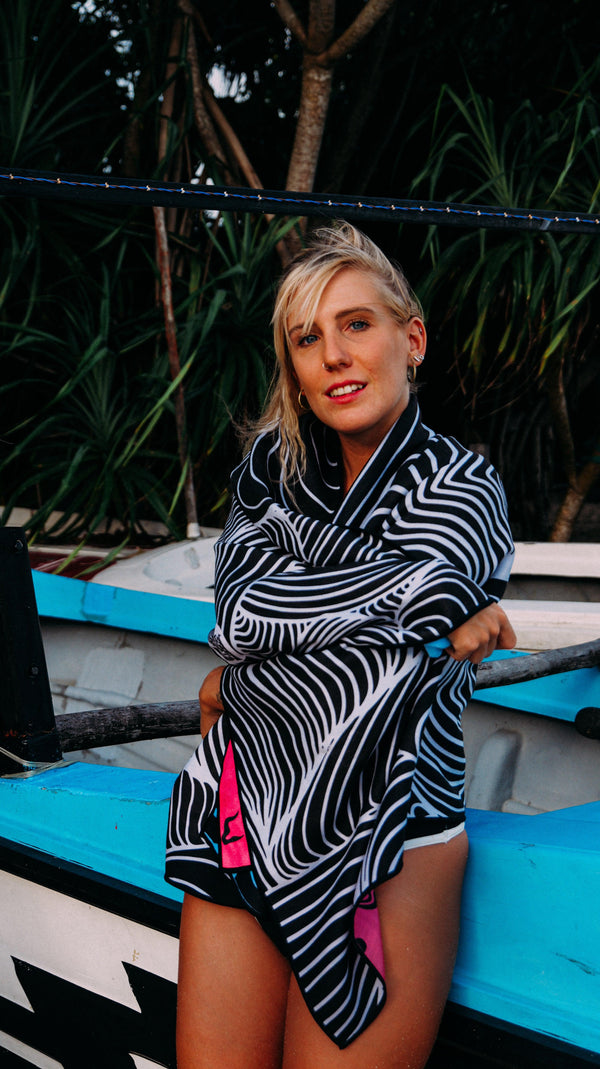 A woman on a beach wrapped in a Happy Faced Towel