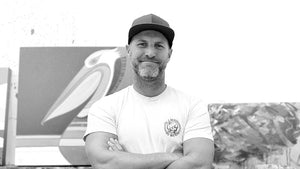 Artist Erik Abel standing with arms crossed in his studio.