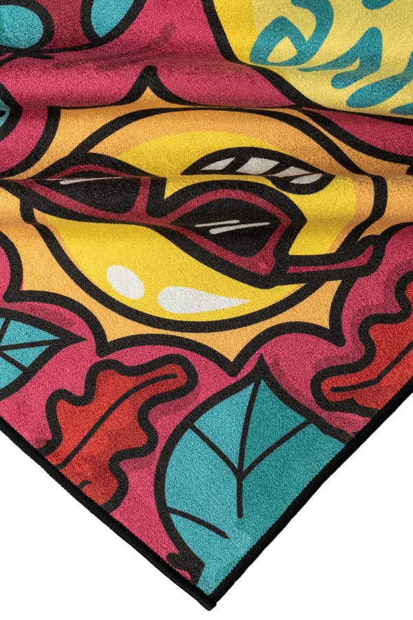 A close-up of a towel corner featuring a colorful cartoon-like design. The visible section shows a yellow sun wearing red sunglasses, surrounded by bright pink, teal, and orange abstract shapes and leaves. The bold black outlines give the design a playful and vibrant look, with the towel's textured fabric adding depth to the whimsical imagery. High Quality Towel