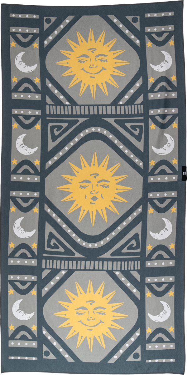 A towel featuring a celestial-themed design with yellow suns radiating rays and white crescent moons with stars. The center has large, smiling suns, while the sides are adorned with moons. Geometric patterns in gray and dark teal frame the design, adding intricate details. The towel’s symmetrical layout and dotted accents create a playful and artistic vibe, inspired by cosmic imagery with a modern, vintage feel.