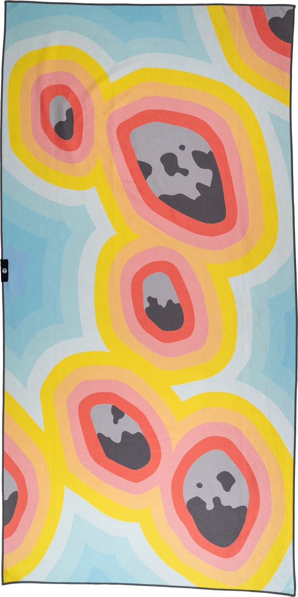 A towel with a vibrant, abstract design featuring organic shapes resembling colorful lava lamps or geodes. The main design consists of irregular ovals in shades of yellow, pink, and orange with gray centers, set against a light blue and white background. The pattern repeats in a dynamic, flowing arrangement, evoking a playful and psychedelic aesthetic. The color scheme and shapes create a bold, eye-catching visual.