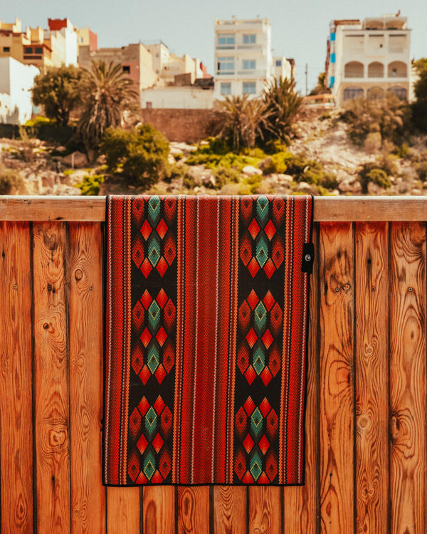 A Happy Faced Towel Hangs on a fence in a backyard somewhere in Morocco.