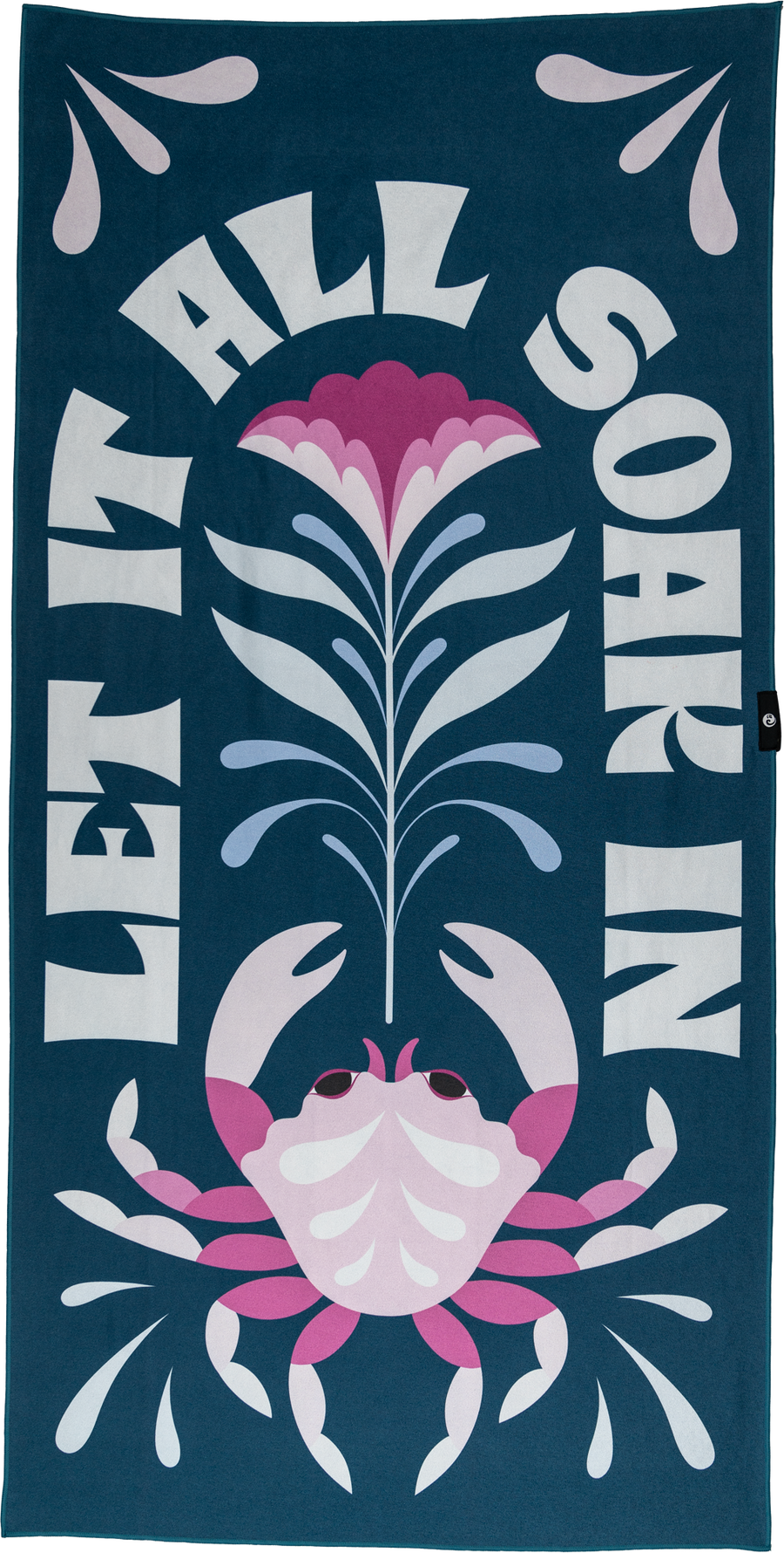A playful towel with a pink crab, flower, and water droplets, framed by the bold text "LET IT ALL SOAK IN." The dark teal background and bright accents create a fun, vibrant beach vibe.