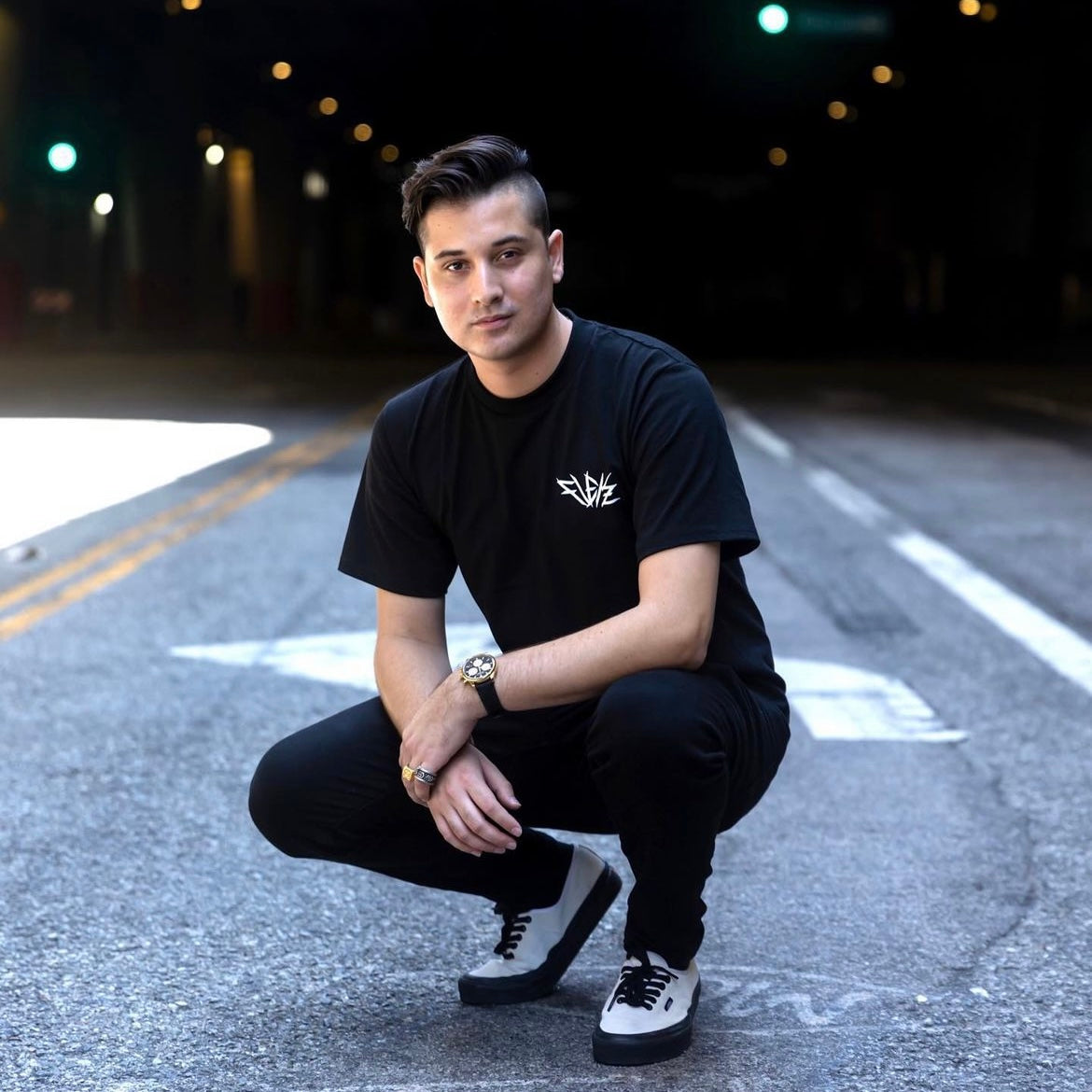 Artist Flekz crouching in a city street