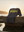 Grey t-shirt with 'HAPPINESS IS DOPE' text on a rock by the ocean at sunset