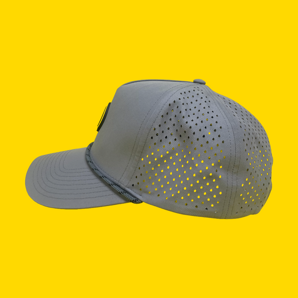Side view of the gray Happy Faced cap with perforated design on a yellow background