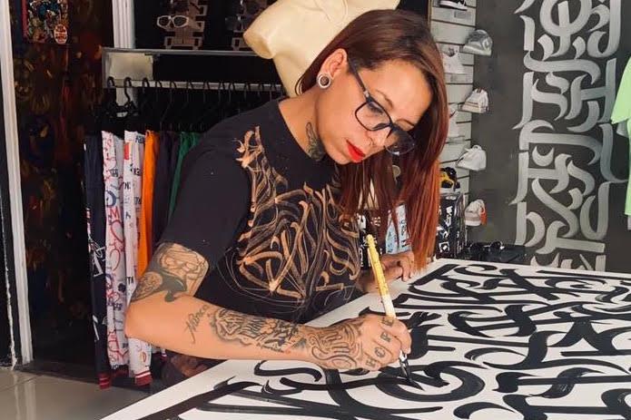 Artist Mari Monteiro drawing expressive black lettering