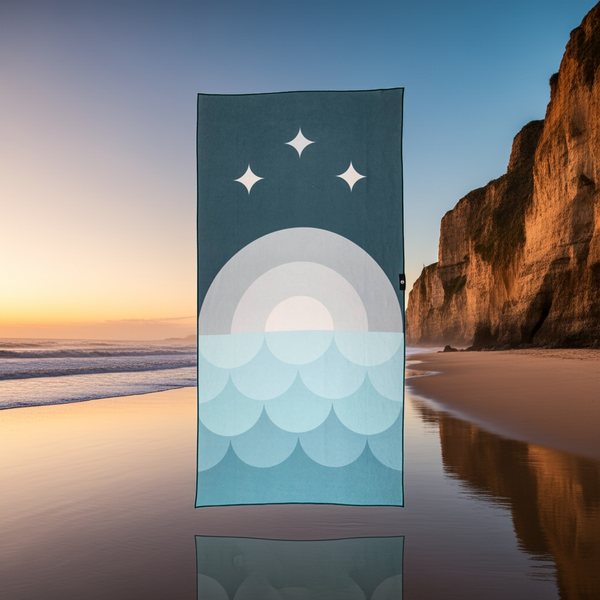 Towel with celestial design on a beach at sunset