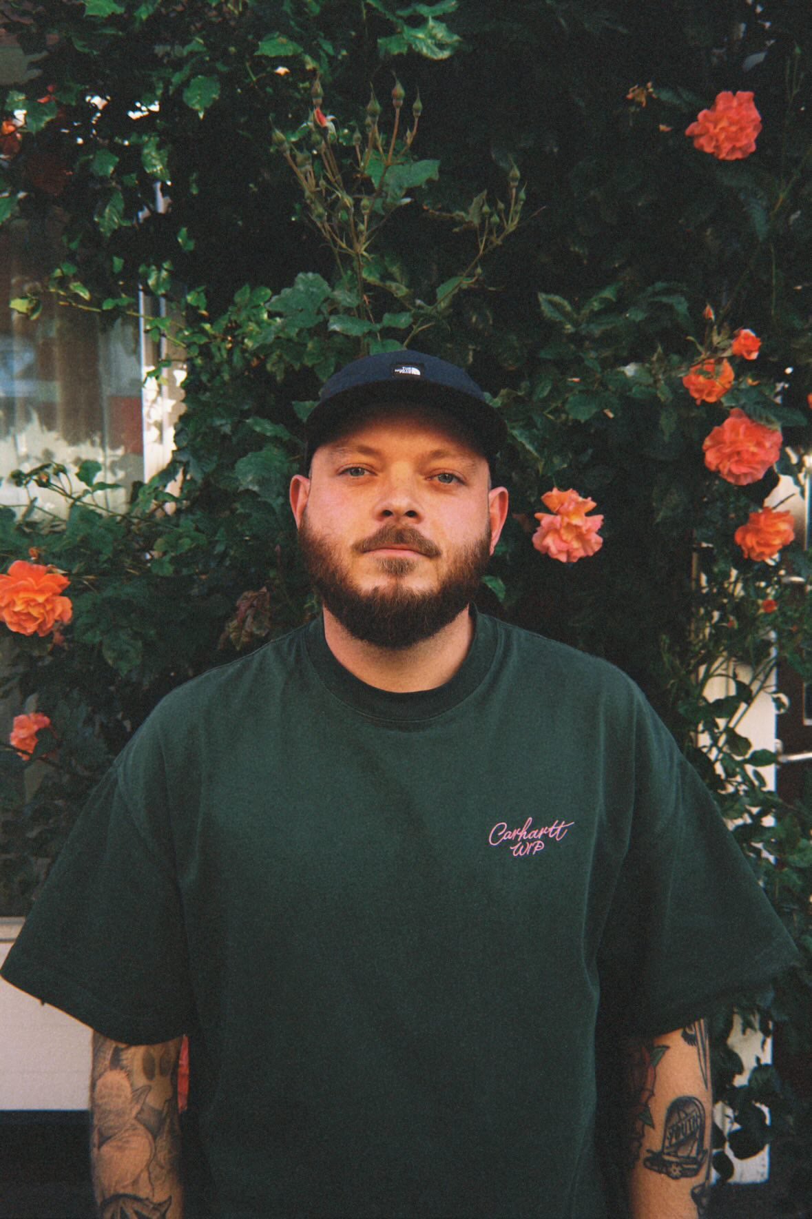 Graphic designer Sebastian Kern standing among flowering plants