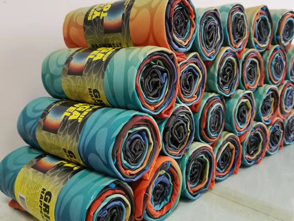 Stack of colorful yoga towels rolled up with Happy Faced Packaging on a white background