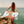 A happy faced towel held by a girl in a bikini