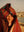 a woman with a Happy faced towel on her head smiling at the beach in Morocco.